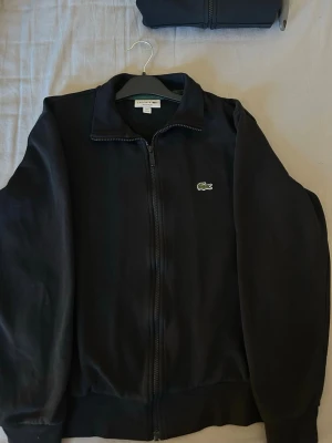 Lacoste zip cardigan - Säljer en Lacoste kofta i storlek M, mycket bra skick och inga skador. Nypris 2095. Pris kan diskuteras, leverans samma dag eller dagen efter🥰