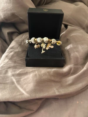 Guldigt berlockarmband  - Snyggt armband i guldfärgad metall med flera detaljerade berlocker, köpte det i global village i Dubai 💞.