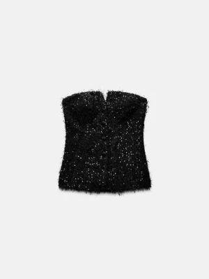 Svart glittrig tubtopp från Zara - Säljer en svart tubtopp från Zara med glittriga detaljer och fluffig textur. Toppen är axelbandslös och har en snygg bandeau-form som ger en trendig look. Perfekt för dig som vill sticka ut med en cool och festlig stil.
