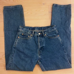 Blå Weekday Space Relaxed Straight Jeans - Säljer ett par blå Weekday Space Relaxed Straight Jeans i rak modell. Klassisk femficksdesign, normal passform och snyggt mellanblå tvätt. Tillverkade i tåligt jeanstyg med läderpatch bak i midjan. Perfekta för en chill och stilren look.