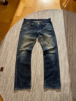 Burberry Black Label jeans  - Ett par jeans från Burberry Black Label, en kollektion som numera är nedlagd.  Jeansen har en lätt bootcut-passform och flera detaljer, såsom lock över bakfickorna samt Burberry-loggan på en av bakfickorna.  De har en mycket fin tvätt/fade och inga defekter, förutom ett mycket minimalt slitage vid hälarna.  Tveka inte att höra av dig om du har frågor, vill se fler bilder eller komma med prisförslag.  Mått: Längd: 100 cm Bredd: 41,5 cm