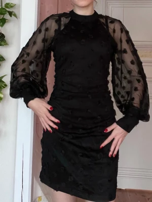 Klänning  - Svart klänning med små rosor och tyllärmar. Den är superstretchig så skulle säga att den passar xs-m. Endast använd en gång. Köpt för ca 800💕