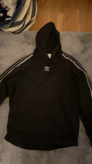 Adidas hoodie - Adidas hoodie med tryck i mitten av tröjan 