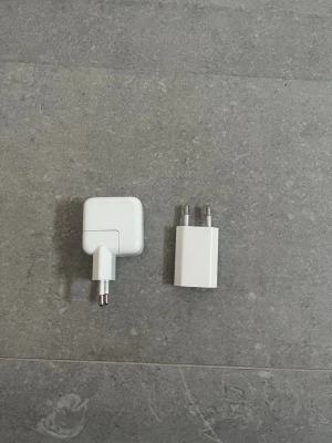 Apple USB Väggadaptrar (2-pack) - Säljer två original Apple USB väggadaptrar för laddning av iPhone, iPad eller andra Apple-enheter. Båda har EU-kontakt och USB-A port. Mindre yttre slitage syns, men fungerar utmärkt. Perfekt som extra laddare hemma eller på jobbet.