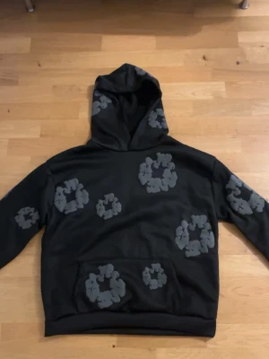 Svart vadderad hoodie med mönster – bra skick - Säljer en svart vadderad hoodie. Storlek: S Skick: nytt skick, inga hål eller fläckar. Varm och skön, perfekt till höst/vinter. Säljs pga passform. Skickas eller möts upp.
