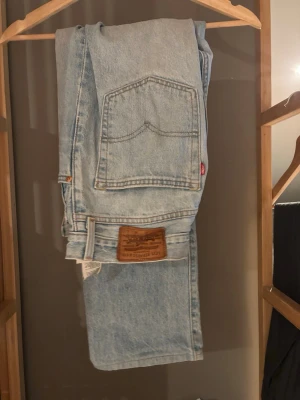 Levi's 501 ljusblå jeans straight fit - Klassiska Levi's 501 jeans i ljusblå tvätt med raka ben och normal passform. Jeansen har fem fickor, knappgylf och den ikoniska läderpatchen bak i midjan. Tillverkade i slitstarkt bomullsjeansmaterial och har den röda Levi's-taggen på bakfickan.