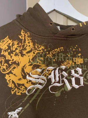 Jävligt tuff hoodie med tryck fram- och baktill  - Supercool hoodie med tryck i vitt, grönt och gult. Perfekt för en mysig men unik outfit. 