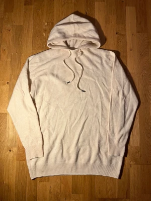 Merinoull hoodie - Säljer denna riktigt snygga och sköna hoodien/tröjan🤩. Beige färg, perfekt att ha i garderoben och passar till ALLT👊. Toppskick💯. Strl M/L. Hör av dig om du har några frågor!