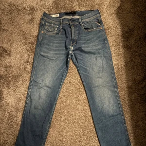 Replay jeans - Snygga blå Replay Anbass jeans i slim fit och ljusa slitningar. Helt oanvända! 