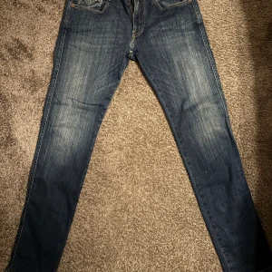 Replay Anbass jeans blå 32/32 - Säljer ett par Replay Anbass jeans i klassisk blå tvätt med snygga slitningar! 