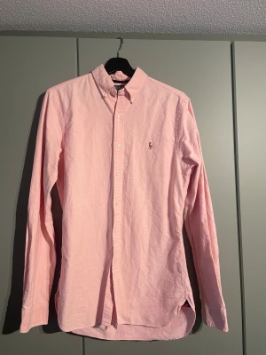 Rosa skjorta Polo Ralph Lauren  - Klassisk rosa skjorta från Polo Ralph Lauren i slim fit-modell. Ganska lång i modellen så passar även M kanske till och med L