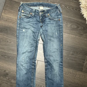 True religion jeans vintage - Vintage True religion jeans med snygga slitningar. Köpta på Plick, förra ägaren har sytt förstärkning i grenen och sytt de tajtare i låren. De är raka men har uppklippningar vid bensluten. Storlek 26 39 midja (78), 16 från gren till midja, innerben 76 Benöppning 18 (uppklippt). Dragkedja o knapp. 