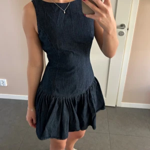 Mörkblå jeansklänning med volang - Säljer denna supersnygga jeansklänning från Zara. Köpt i Spanien och använd en gång, så iprincip nyskick! Skriv vid frågor eller fler bilder🥰