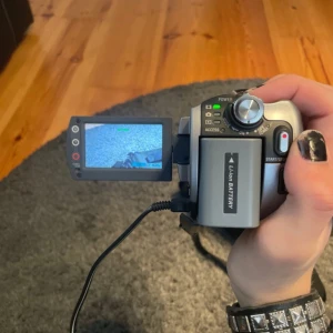 Sony Handycam DCR-SR50 - Sony Handycam DCR-SR50 videokamera med Carl Zeiss Vario-Tessar lins, 30GB HDD, 800x digital zoom och vridbar LCD-skärm. Fungerar utmärkt, komplett med väska och kablar. Nightvison ingår i kameran. Mindre bruksspår men i gott skick. Batteriet rekommenderars att bytas eftersom den inte håller laddningen så bra det är väldigt lätt att hitta.