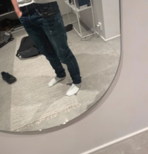 Replay jeans mörkblå med feta slitningar  - Säljer ett par feta Replay jeans i mörkblå tvätt med slitna detaljer och kontrastsömmar. Klassisk femficksmodell med tydliga slitningar på fickor och ben, samt Replay-logga på bakfickan. Jeansen har slim  passform och är tillverkade i robust denim.