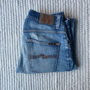 Nudie Jeans Grim Tim 31/34 - Hej! Säljer nu mina Nudie Jeans i den populära modellen Grim Tim, med en slim/straight passform. De är i fint skick. De har en riktigt snygg färg med en snygg tvätt. De är i storlek W31 L34. Mått 📐: Midja: 40 cm Längd: 110 cm. Hör av dig om du undrar över något annat! 