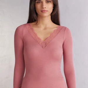 Intimissmi tröja - Supersöt långärmad topp i dammigt rosa från Intimissimi. V-ringad med bred spetskant runt halsringningen och vid ärmsluten. Tunn och mjuk i bomullsmix, perfekt att styla med jeans eller kjol för en chill look. Sesongs färg så finns inte att köpa längre vilken gör den mer udda!