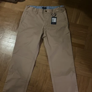 Beiga byxor från Gant - Ett par helt nya riktigt stiliga beiga byxor från Gant. De fungerar fint till vardagligt bruk och till finare tillfällen. Original pris 699(se bild 3).
