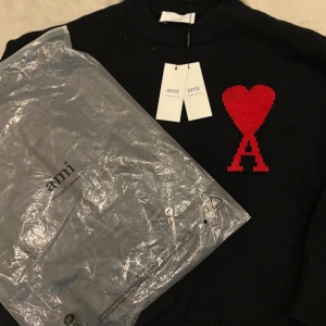 Ami Paris stickad tröja – svart -  Svart stickad tröja från Ami Paris. Stilren och clean design med hög kvalitet. Oanvänd och i riktigt fint skick.  ✅ Oanvänd ✅ Fraktas samma dag  Kan alltid diskuteras vid snabb affär 💯 