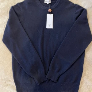 Davida cashmere helt ny - Snygg mörkblå rundhalsad tröja från Davida i 100% kashmir. Tröjan har ribbade muddar vid ärmslut och nederkant, samt långärmad passform. Perfekt för dig som gillar stilrena och mjuka plagg med lyxig känsla. Ny med tags 