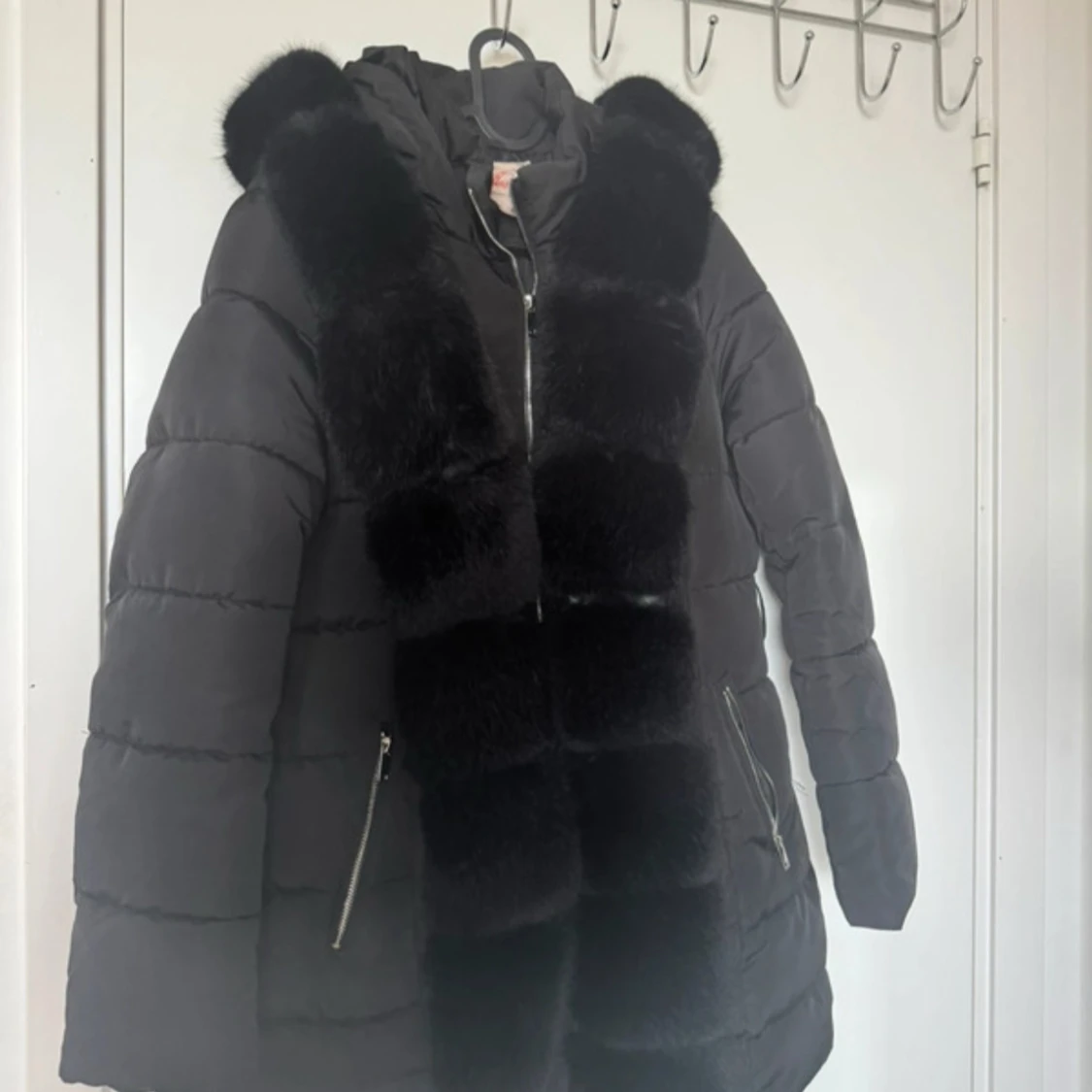 Svart pufferjacka med pälsdetaljer