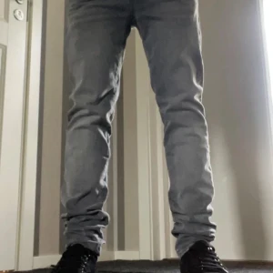 Grå jeans från Jack & Jones, 30/32 - Säljer ett par snygga grå jeans från Jack & Jones i storlek 30/32. De har klassisk femficksdesign, raka ben och diskret tvättad look. Passar dig som gillar stilrena och moderna jeans med normal passform. Perfekt till sneakers och hoodie.