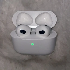 AirPods Gen 4 - Säljer ett par Apple AirPods Gen 4 i mycket fint skick, komplett med originalkartong, laddningskabel och manualer. Hörlurarna och laddningsfodralet är rena och utan synligt slitage. Perfekt för trådlös musik och samtal med hög ljudkvalitet.