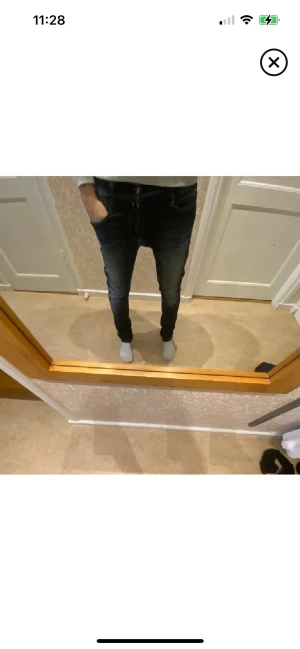 Mörkblå skinny jeans med stretch - Snygga mörkblå jeans med skinny passform och lätt tvättade detaljer. Modellen har klassiska fem fickor, dragkedja och knapp framtill. Jeansen är tillverkade i stretchigt denim för extra komfort och sitter tajt längs benen.
