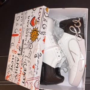 Dolce & Gabbana vita och svarta sneakers - Dolce Gabbana skor. Nypris ligger runt 5000kr. Använda endast 3 gånger inomhus på mässor. Dom är som helt nya och säljer dom eftersom dom blivit för små