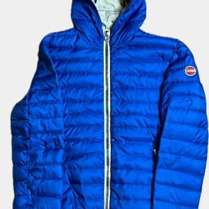 Blå Colmar pufferjacka med huva - Snygg blå pufferjacka från Colmar med huva och vit dragkedja framtill. Jackan har quiltad design, Colmar-logga på ärmen och är tillverkad i lätt syntetmaterial. Perfekt för kyliga dagar. Nypris på denna ligger runt 5000kr, värt pris är 1299kr en helt sjukt deal för denna jacka!!!