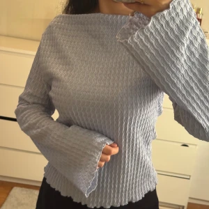 Ljusblå ribbad långärmad tröja - Säljer en ljusblå långärmad tröja med ribbad struktur och vida ärmar.  Aldrig använd 