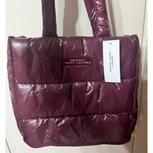 Marc Jacobs tote bag - Säljer en jättefin, ny Marc Jacobs tote bag i en vinröd lila färg. Den är rymlig och passar perfekt som julklapp. Pris kan diskuteras vid snabb affär.   Om du undrar något tveka inte på att skriva eller om du vill ha fler bilder.