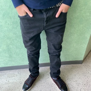 Svarta slim jeans från Dsquared2 - Säljer ett par svarta jeans från Dsquared2 med slim passform och klassisk femficksdesign. Jeansen har en snygg Dsquared2-logga baktill i midjan och är tillverkade i stretchigt denim för en bekväm känsla. Perfekt för dig som gillar stilrena och moderna jeans. 52≈32/32
