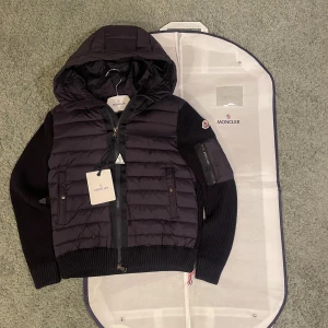 Navy moncler cardigan  - Säljer denna Moncler cardigan i färgen navy fast den ser ut som en svart men den är navy. Den är helt oanvänd och den är i storlek M .