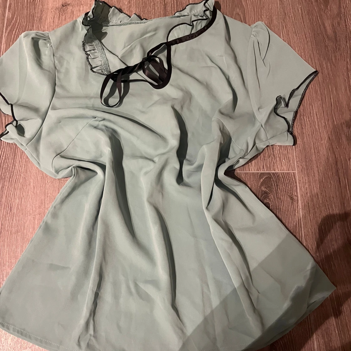 Grön blus med svarta detaljer