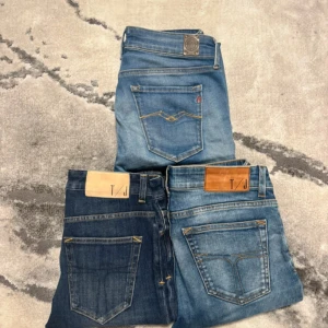 Replay Jeans  - Tre par  jeans i olika blå tvättar från T/J och Replay. Ett par är mörkblå, de andra två är ljusare med slitningar och snygga detaljer på bakfickorna. Klassisk femficksmodell, smal passform och bekvämt jeansmaterial. Perfekta för dig som gillar en tajt look.