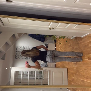 Grå bootcut jeans med svarta detaljer - Hej! Jag säljer ett par grå Nelly jeans med bootcut-modell och svarta sömdetaljer på bakfickorna. Jeansen har klassisk femficksdesign, låg midja och är tillverkade i ett mjukt denimtyg. Perfekta för dig som gillar en avslappnad men ändå trendig look. 🥰