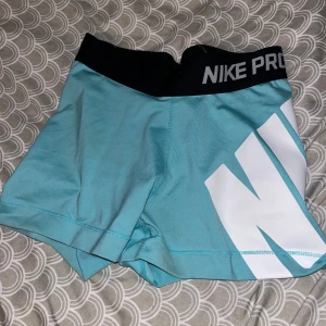 Nike pro ljusblå/turkåsa träningsshorts  - Jättefina träningsshorts i fin blå färg. Stor Nike text på vänstra höften. Sköna att träna i, stretchigt material. Använda fåtal gånger. Storlek xs, säljs då dem börjar bli för små🩵