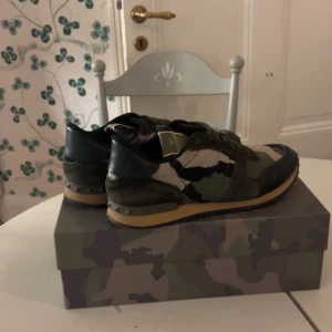 Valentino Rockrunner sneakers camouflage - Säljer ett par Valentino Rockrunner sneakers i grön, beige och svart camouflage. Skorna har snörning, platt sula och rund tå. Materialmix med mocka och textil, samt detaljer i skinn. Kommer med originalkartong och dustbags. Riktigt snygga och unika sneakers!