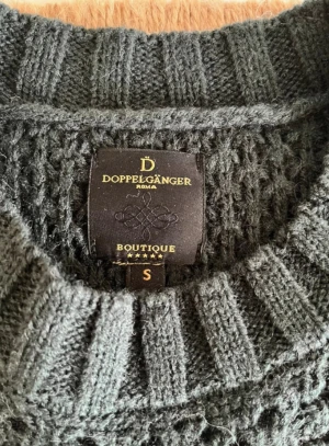 Mörkgrön stickad tröja från Doppelgänger - Mysig mörkgrön stickad tröja från Doppelgänger med grov kabelstickning och ribbade muddar. Tröjan har rund halsringning och långärmade ärmar, perfekt för kyliga dagar. Snygg struktur och klassisk look som funkar till allt. Helt ny. Köpt i Italien 🇮🇹.