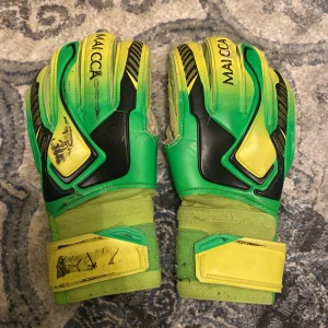  målvaktshandskar MAICCA - Säljer ett par coola målvaktshandskar från MAICCA i grönt och gult med svarta detaljer storlek 6 .Perfekta för dig som älskar fotboll och vill sticka ut på planen. Använd en bit men funkar fortfarande bra för bra pris 