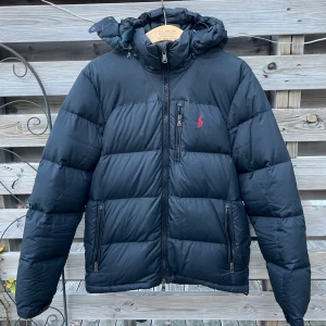 Ralph Lauren Svart Dunjacka  - Svart Ralph Lauren dunjacka, lappen avriven då den skavde men uppskattas till storlek M. Helt okej skick, finns en del lappade smålagningar, kom dm om ni vill se alla. I övrigt bra skick. 799 eller prisförslag. 