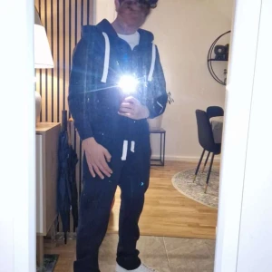 Mörkblå sett (hoodzip och byxor) från Russedress S - Mörkblå hoodie och byxor från Russemerch i storlek S med vit snörning och broderad logga på ärmen. Tröjan har huva, dragkedja framtill och två fickor. Perfekt för chill dagar och har en klassisk streetwear-vibe. Har aldrig använt ute. Ord. Pris på hemsidan, ca 1350 kr. Pris kan diskuteras.