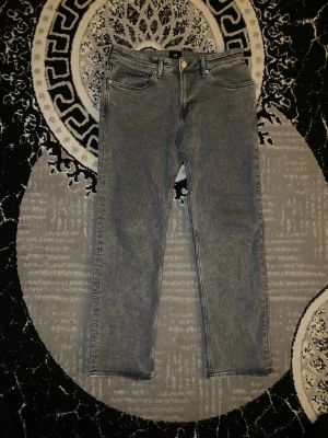 Grå jeans från H&M, regular fit 32/32 - Säljer ett par gråa jeans från H&M i regular fit, storlek 32/32. Klassisk femficksmodell med raka ben och knappgylf. Jeansen har en tvättad look och passar perfekt till en avslappnad stil. Materialet är slitstarkt och bekvämt bomullstyg.köpt för 499 kr 