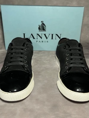 Svarta sneakers från Lanvin - Snygga och klassiska lanvin sneakers. Skorna är k str uk 7 sitter som eu 42. Skorna är i gott skick och sulkräm har används för att fräsha till de lite tveka. Tveka inte på att kontakta mig vid minsta fundering. Dustbags fås med.