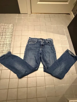 Blå jeans från Replay modell THAD - Säljer ett par klassiska blå jeans från Replay, modell THAD. Jeansen har fem fickor, raka ben och normal passform. Snygg tvätt med lätt slitning och detaljerade sömmar. Perfekta till vardagslooken och funkar året runt.