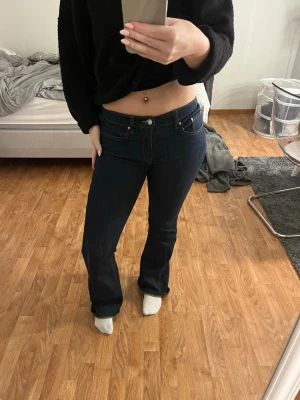 Mörkblå bootcut jeans  - Säljer ett par mörkblå jeans från Gina i klassisk bootcut-modell. Jeansen har låg midja, skit snygga. Använda 1 gång