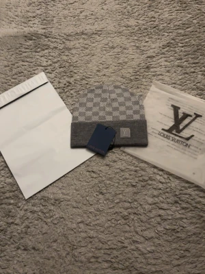 Lvmössa - Perfekt inför denna säsongen. Passa på. Grå rutig mössa. One size men formas till ditt huvudform. Fraktas direkt efter köp!!