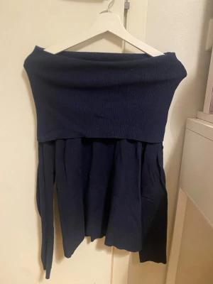 Mörkblå offshoulder klänning Soya Concept - Supersnygg mörkblå offshoulder klänning från Soya Concept. Klänningen har en ribbad överdel och ett mjukt, flowy fall. Perfekt för dig som gillar en enkel men ändå chic look. Materialet känns stickat och ger en mysig känsla.