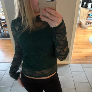Mörkgrön spetsblus från BikBok - Säljer en mörkgröna spetströja från BikBok. Det finns ett linne som sitter fast i en tråd som man kan ta bort enkelt själv, ifall man vill ha tröjan utan linnet under💗